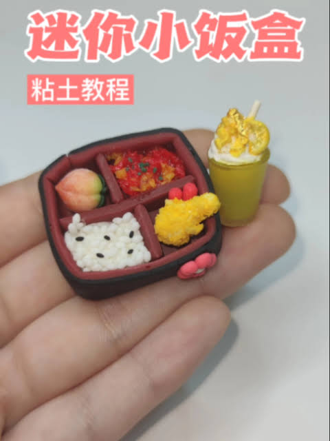 Tiny clay lunch box charm with rice and side dishes made in a workshop