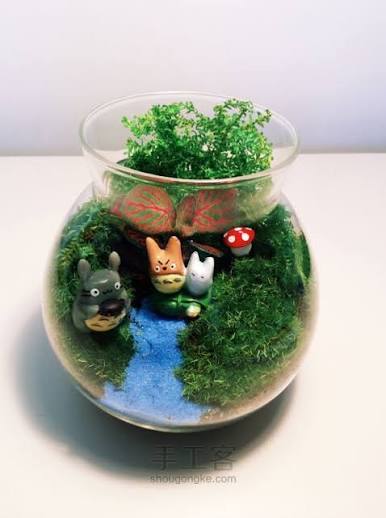 Two glass jar terrariums with moss and tiny figures on a windowsill