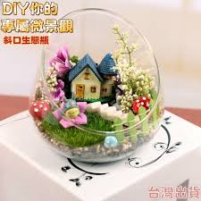 Miniature landscape terrarium with a small house and flowers