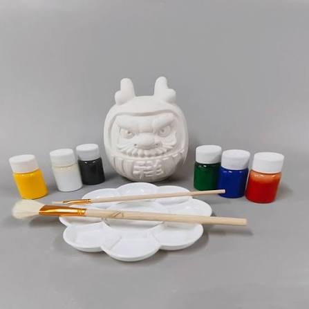 Non-toxic paint pots brushes and a plaster figurine set up for a kids class