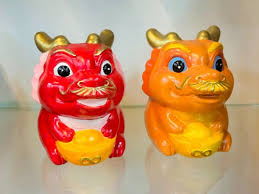 Two hand painted lion dance figurines finished by kids in a painting class