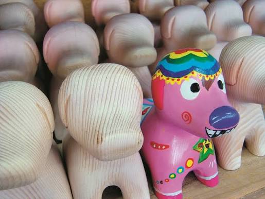 Blank plaster figurines and a painted pink elephant in a kids painting studio