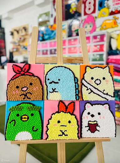 Finished kids craft pictures displayed on easels inside a DIY party studio