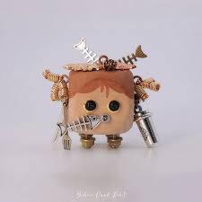 Robot figure with a boxy head and wire arms built from found objects