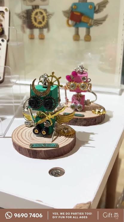 Small robot dioramas displayed under glass domes on wooden stands